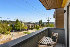 西雅图Modern Luxury Home with EV Garage, Office, Bike & Balcony, WFH & Family Friendly的一张木椅,位于一个享有街道景色的阳台