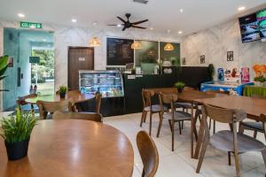 彭亨Villa Renai Resort的配有木桌和椅子的餐厅