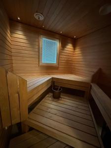 卡亚尼Lumikukka Vuokatti的木制桑拿房,设有窗户和桶
