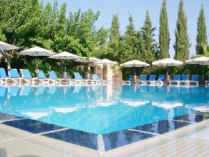 帕福斯Apollonia Hotel Apartments的一个带椅子和遮阳伞的大型游泳池