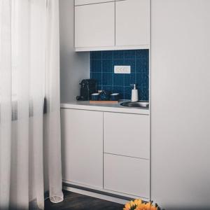 普雷韦扎BLUE LUXURY SUITES的厨房配有白色橱柜和水槽