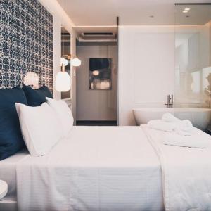 普雷韦扎BLUE LUXURY SUITES的卧室配有一张白色大床和浴缸