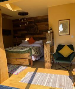 Donington on BainThe Vikings Retreat的一间卧室配有一张床和一把椅子
