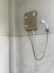 蔻立考拉桑迪之家旅馆的带淋浴的浴室,浴室的软管与墙壁相连