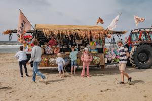 赞德沃特B&B de Drukkerij Zandvoort - luxury private guesthouse的一群人站在海滩上的食物车周围