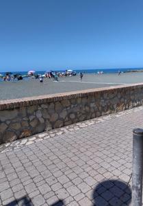 拉迪斯波利Casetta Seaside的海滩上的石墙,背景的人
