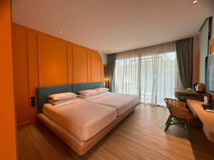 七岩Banlansuan Resort SHA Plus的一间卧室配有一张大床、一张桌子和一个窗户。