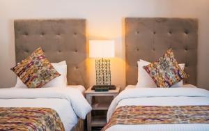 罕萨Offto Resort Hunza的酒店客房设有两张床和一张桌子上的台灯。