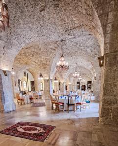 拜特丁米尔阿明宫酒店的石头建筑中带桌椅的用餐室