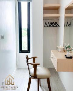 那空拍侬府นครพนม นอร์ดิกเฮ้าส์的一张椅子,位于带桌子和窗户的房间