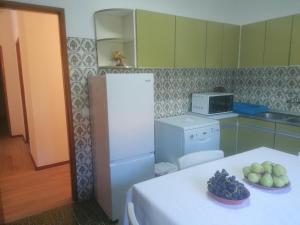River City House的厨房配有白色冰箱和带水果的桌子。