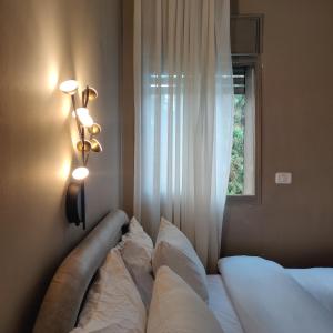海法Urbanica Carmel- Apartments的一间卧室配有带两个枕头的床和窗户