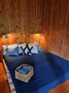 LakajaViesuliškės Lakeside Glamping的一间卧室配有蓝色的床,上面有篮子