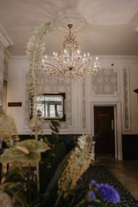 费利克斯托奥威尔酒店的客厅配有吊灯和鲜花桌