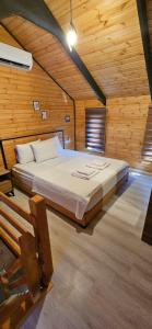 达拉曼Lake house kayacık Resort的木制客房内的一间卧室,配有一张床