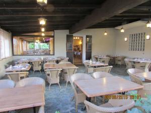 莫里亚尼海滩绿色海岸酒店 的一间空餐厅,配有木桌和椅子