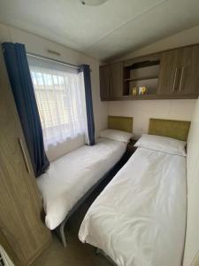 Saint OsythSerenity Holiday Home的小型客房 - 带2张床和窗户