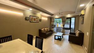 新德里Abode Residency Safdarjung Enclave Near U S Embassy Delhi的一间带桌子的客厅和一间餐厅