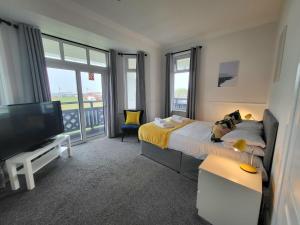 佩恩顿Beach Hotel Torbay的一间卧室配有一张床和一台平面电视