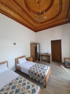 塔什干Chorsu Inn的一间卧室设有两张床和格子天花板
