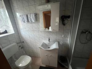 莱奥本Gasthof Knezevic的白色的浴室设有水槽和卫生间。