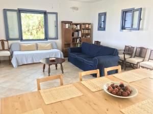 VagiaAegina Vagia Sea Breeze Vacation Villa的客厅配有蓝色的沙发和桌子