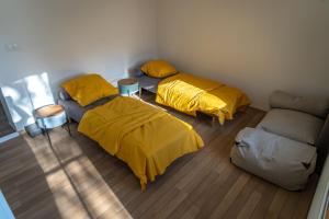 斯皮什新村Raj v Slovenskom Raji 2 samostatné apartmány的带沙发的客房内的两张带黄床单的床