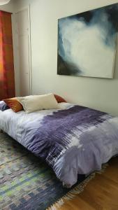 海门林纳Peaceful and beautiful apartment in Hämeenlinna的卧室内的一张床铺,墙上有绘画作品