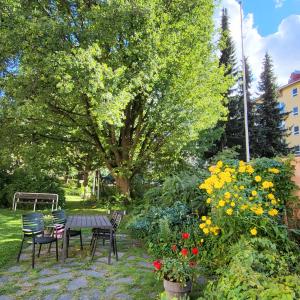 海门林纳Peaceful and beautiful apartment in Hämeenlinna的花园配有桌椅和鲜花