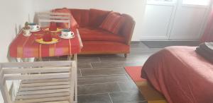 Oye-PlageL Hyppo Camp'的客厅配有红色的沙发和带食物的桌子