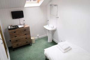 托伯莫里Harbour Guest House的卧室配有水槽、床和电视