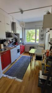 海门林纳Peaceful and beautiful apartment in Hämeenlinna的一间厨房,配有红色橱柜和一张桌子