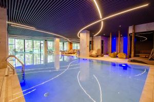 布克维HVOYA Apart-Hotel & SPA的一座带灯光的建筑中的游泳池
