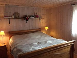 SønstebøBjørnehuset的卧室配有一张床铺,位于带木墙的房间内