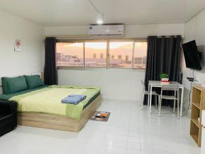 Thung Si KanCondo popular T8 fl.12的一间卧室配有一张床、一张桌子和一个窗户。