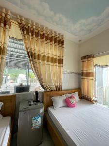 隆海My Linh Motel 976 Đường võ thị sáu long hải的一间卧室设有两张床和窗户。