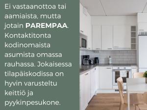 埃斯波Hiisi Homes Espoo Finnoo的白色的厨房配有白色的橱柜和桌子
