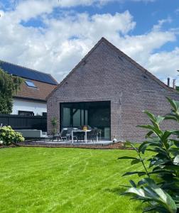 德塞尔Hoeve De Kleinheide的前面有绿色草坪的砖屋