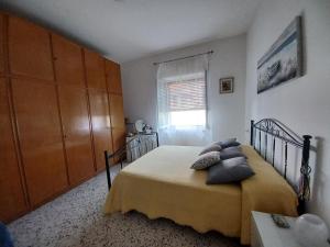 拉维罗A casa di Pissi - apartment的卧室配有带枕头的床铺和窗户。