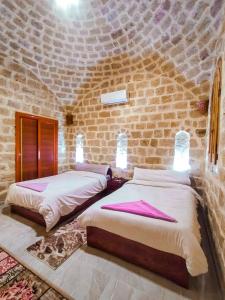 Tunisكمبوند قرية تونس的砖墙客房的两张床