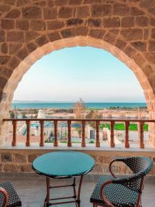 Tunisكمبوند قرية تونس的一个带桌椅的庭院和大海