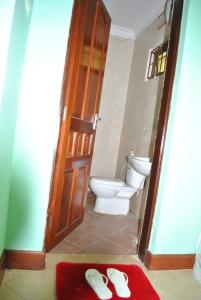 卡拉图Ngorongoro Villa and Restaurant的一间带卫生间和一双拖鞋的浴室