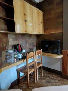 碧瑶Simple Room in a Transient House的厨房配有桌子、两把椅子和炉灶。