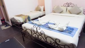 巴克塔普尔Cosy Hotel的配有两张床铺的客房内配有白色枕头