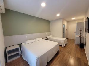 阿瓜斯迪林多亚Pousada Thermas das Montanhas的一间酒店客房,设有两张床和电视