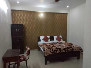 PhāphāmauSpot ON HOME 81265 Hotel Sitasmriti的卧室配有1张床、1张桌子和1把椅子