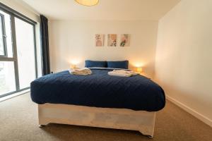 沃金Spacious Apartment in Woking Town Centre的一间卧室配有一张大床和两盏灯