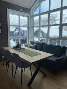 斯特兰达Hytteleilighet på Strandafjellet的带窗户的客房配有桌椅和沙发。