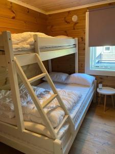 斯特兰达Hytteleilighet på Strandafjellet的小屋内设有一间带两张双层床的卧室