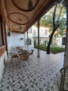 塔什干Chorsu Inn的铺有瓷砖地板,设有带桌椅的庭院。